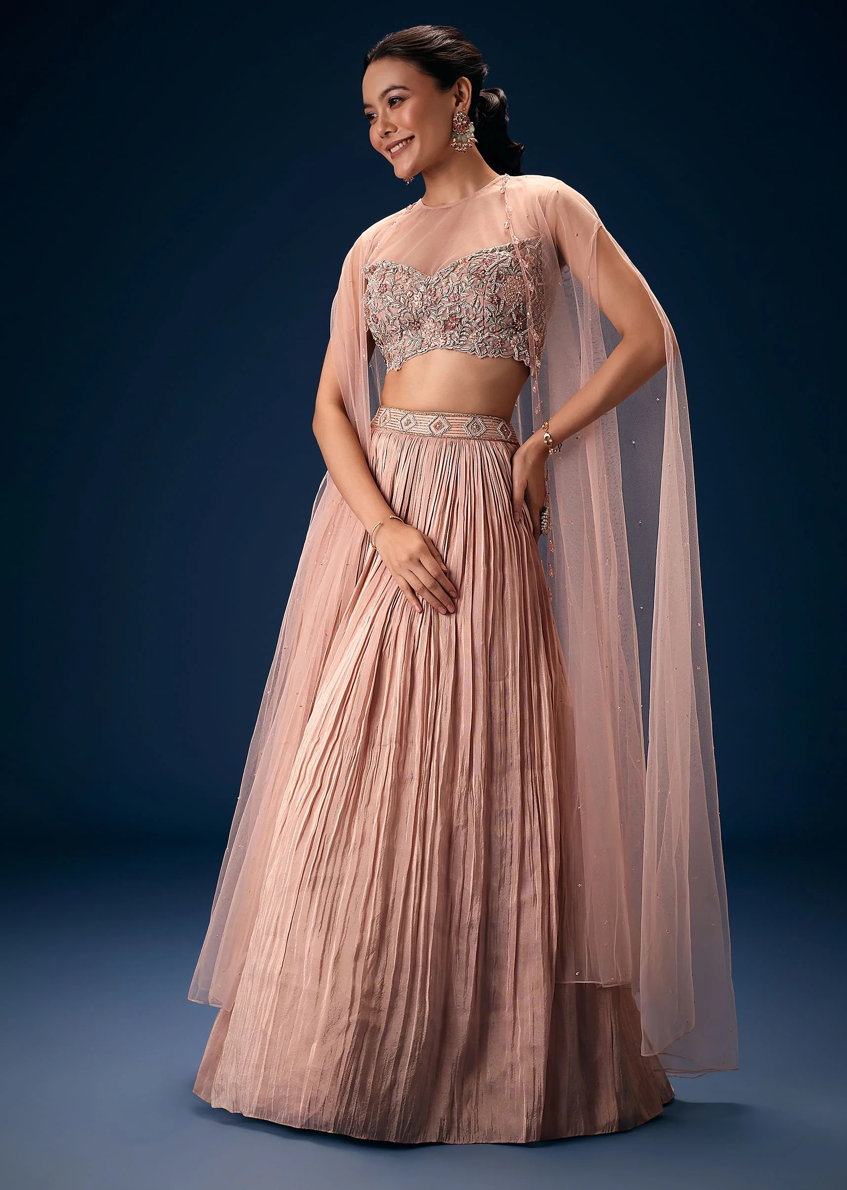 11043-peach-ruched-lehenga-with-embroidered-blouse-and-net-cape-1.webp Peach Ruched Lehenga With Embroidered Blouse and Net Cape