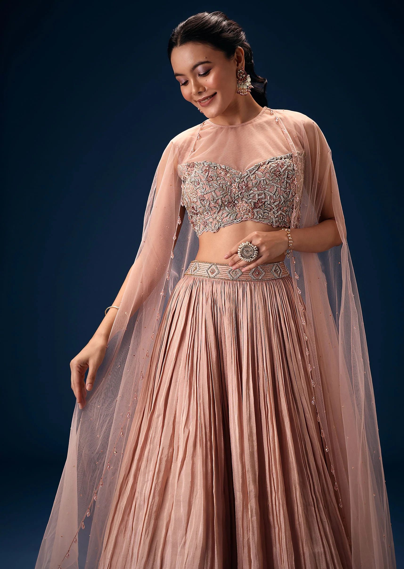 11043-peach-ruched-lehenga-with-embroidered-blouse-and-net-cape-2.webp Peach Ruched Lehenga With Embroidered Blouse and Net Cape