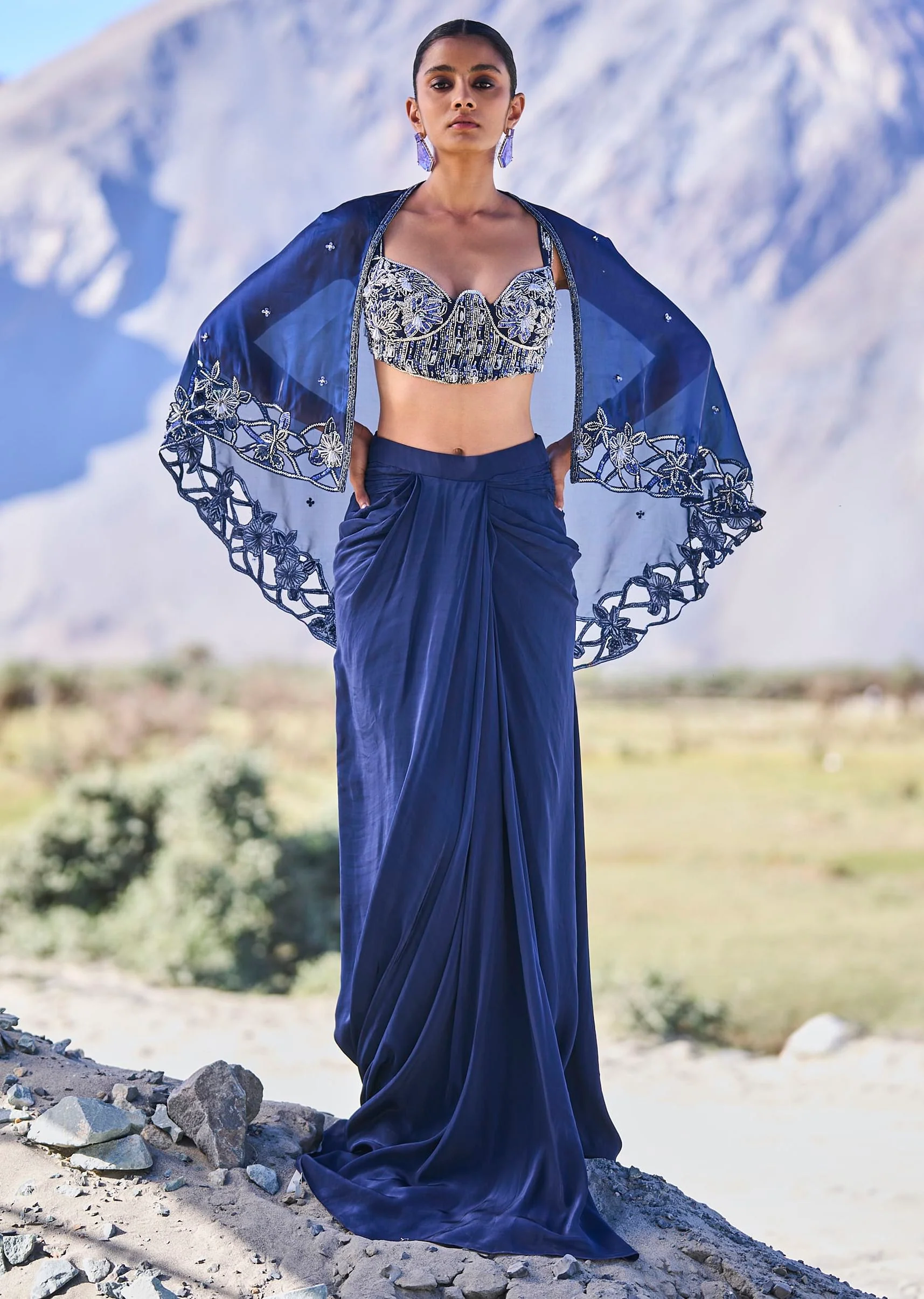 5591-blue-crepe-draped-skirt-with-embroidered-blouse-and-cape-1.webp Blue Crepe Draped Skirt With Embroidered Blouse And Cape