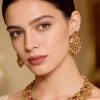 Gold Finish Necklace Set With Temple Style Motifs And Green and Pink Accented Stones