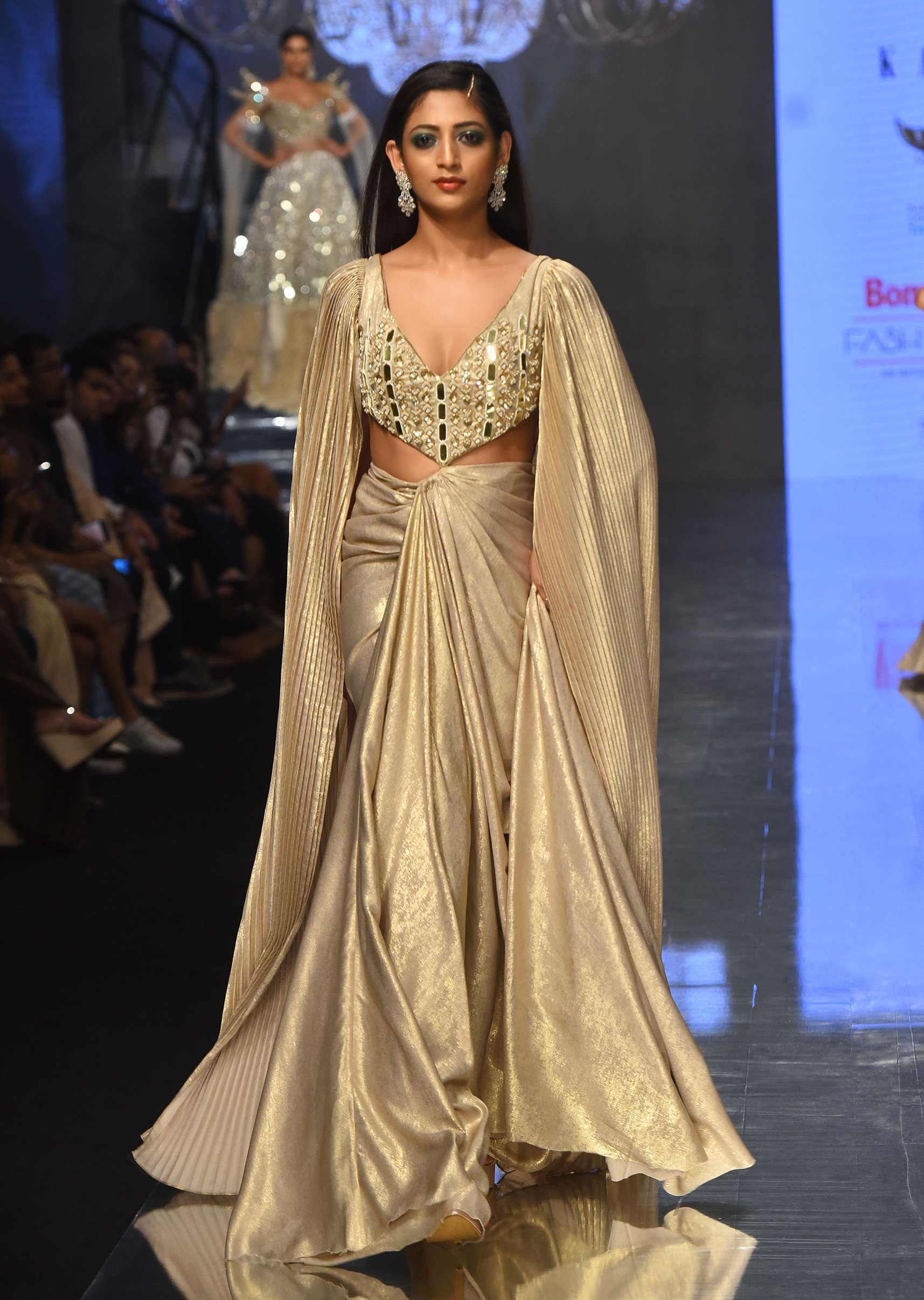 9445-mocha-brown-gown-with-a-pre-pleated-dhoti-skirt-area-and-royal-cape-sleeves-noor-2022-1.jpg Mocha Brown Gown With A Pre-Pleated Dhoti Skirt Area And Royal Cape Sleeves- NOOR 2022